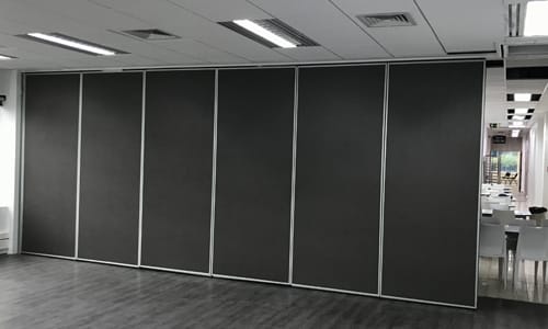 Tabique móvil acústico de paneles cerrado en una sala