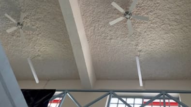 Cielo con celulosa proyectada a la vista en un recinto comercial